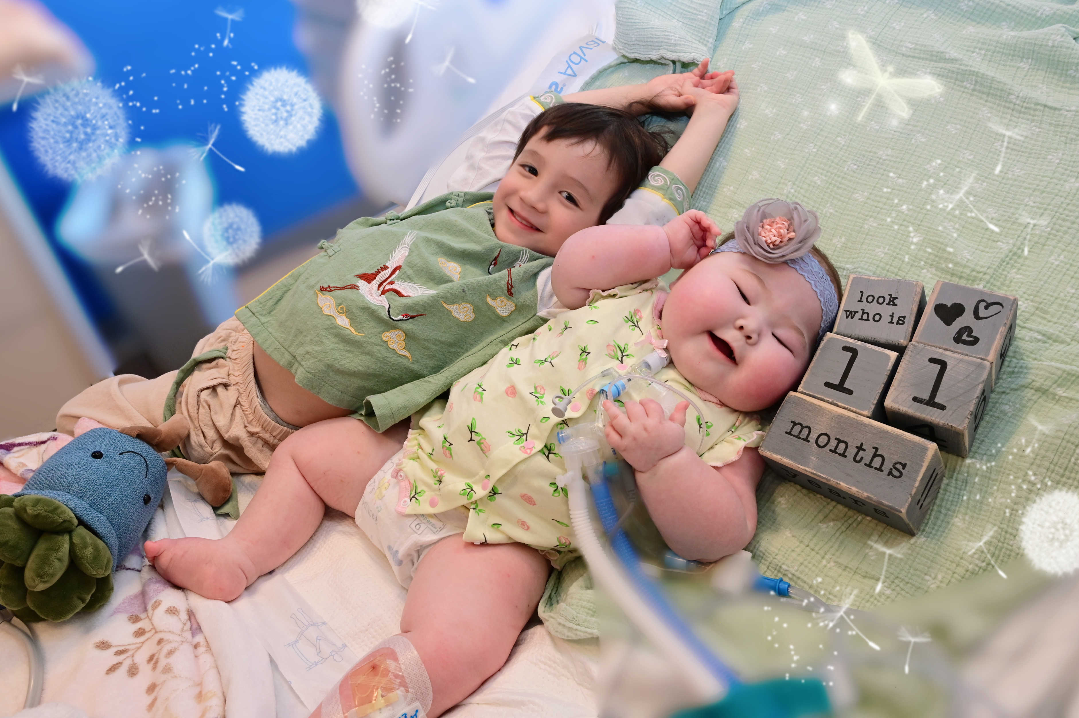 Image of Constance laying with her brother, both smiling