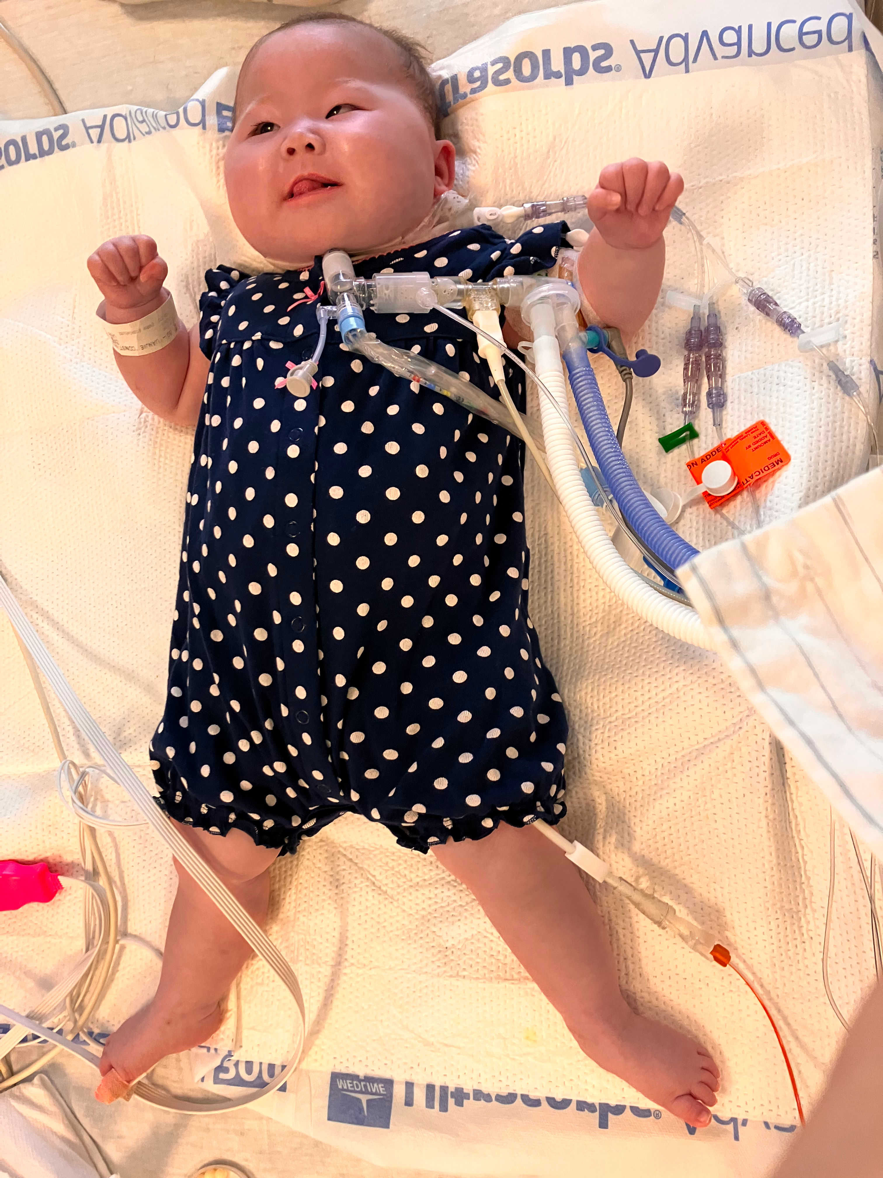 Image of Constance on her back smilign in a polka dot dress